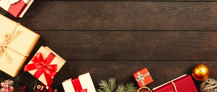 Wrapped gift boxes with ribbon on a wooden surface