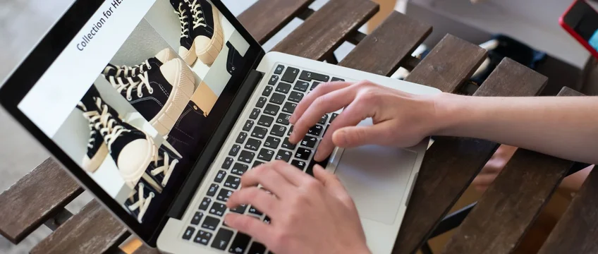 Person browsing an online fashion store on a laptop