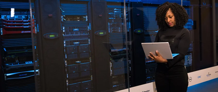 Engineer working on a laptop next to server racks representing web hosting costs in South Africa 2026