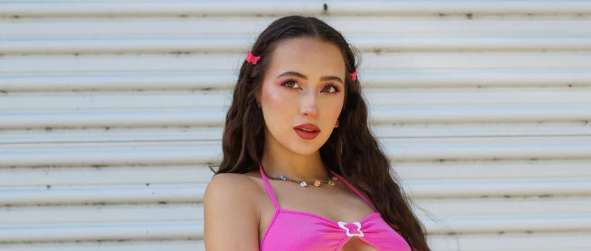 Woman styled in Y2K campus aesthetic with butterfly hair clips and a pink halter top